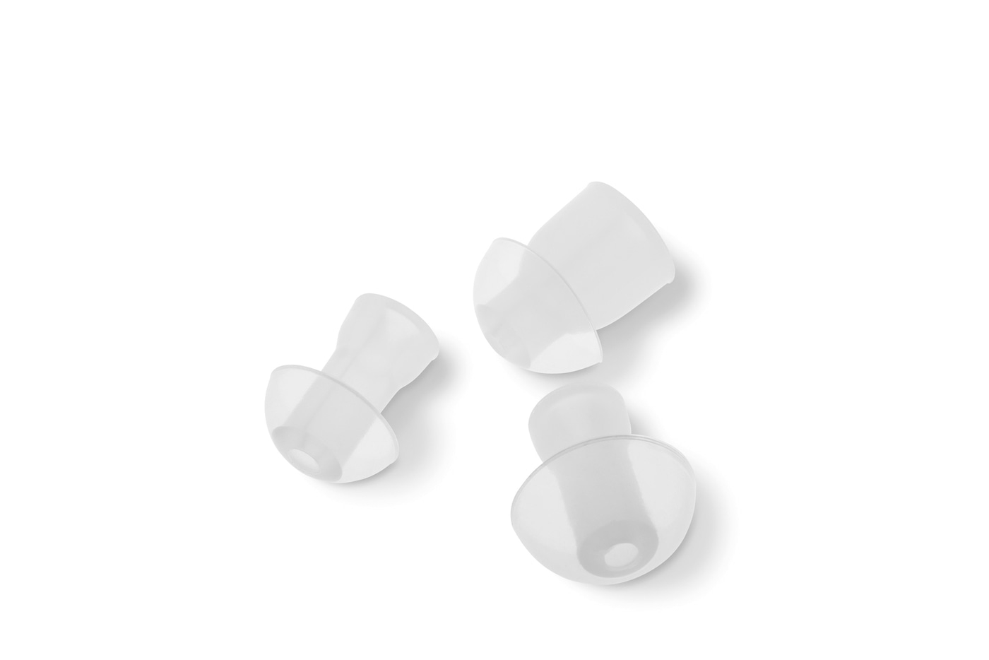 Tres tapones blancos para los oídos sobre fondo blanco, primer plano, aislados, limpios, claros.